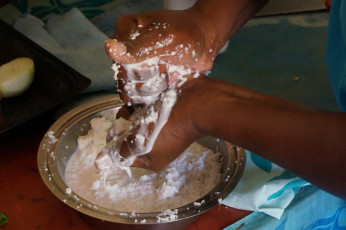 Liti zeigt wie man aus den Raspeln Kokos-Milch gewinnt